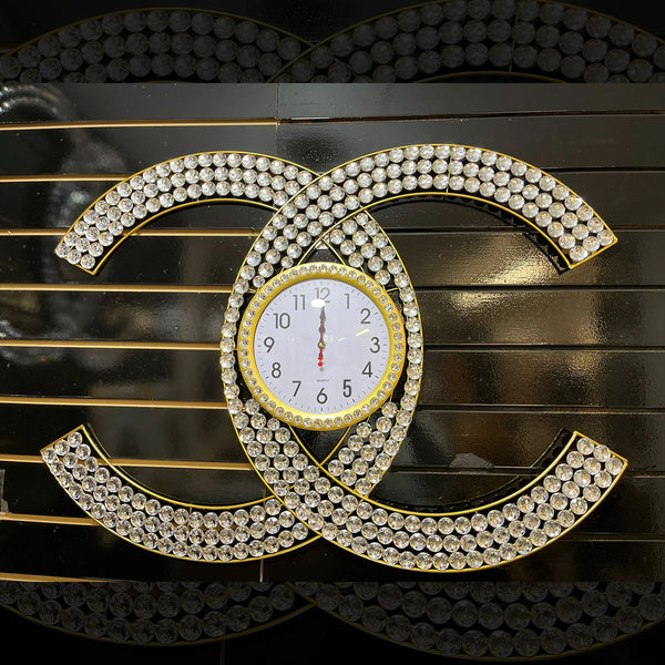 A close-up of a gold clock face with diamond-encrusted numbers and hands, surrounded by a diamond-encrusted 
